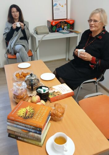 Filomenos Taunytės knygos. Sausainiai, obuoliai, saldainiai, arbata. Moterys geria arbatą. Biblioteka.