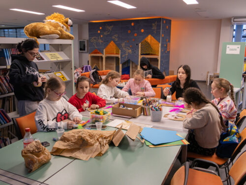 Vaikai Elektrėnų savivaldybės viešojoje bibliotekoje dalyvauja edukacinėje veikloje „Užgavėnių belaukiant". Gamina kaukes.