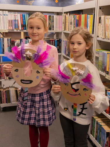 Vaikai Elektrėnų savivaldybės viešojoje bibliotekoje dalyvauja edukacinėje veikloje „Užgavėnių belaukiant". Gamina kaukes.