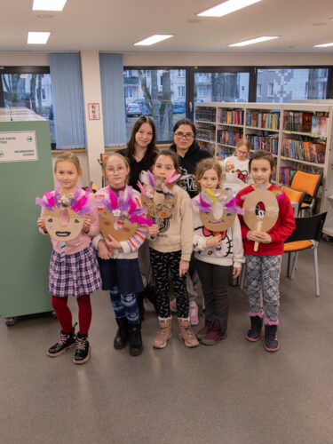Vaikai Elektrėnų savivaldybės viešojoje bibliotekoje dalyvauja edukacinėje veikloje „Užgavėnių belaukiant". Gamina kaukes.